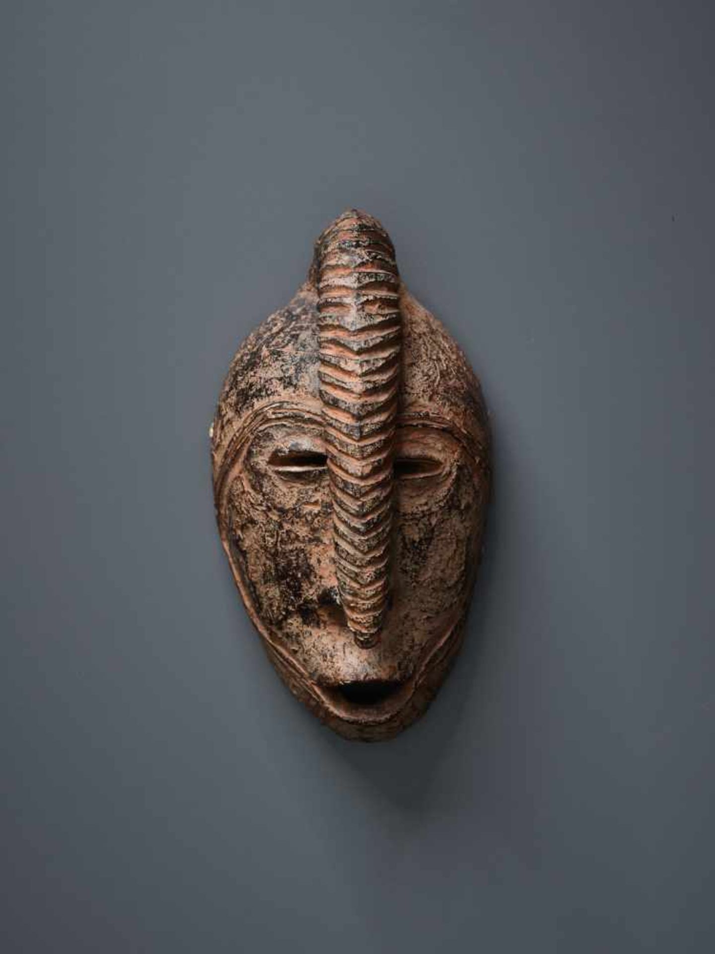 AFRICAN TRIBAL ART, A PASSPORT MASK OF A WARRIORTerracotta with black glaze in some