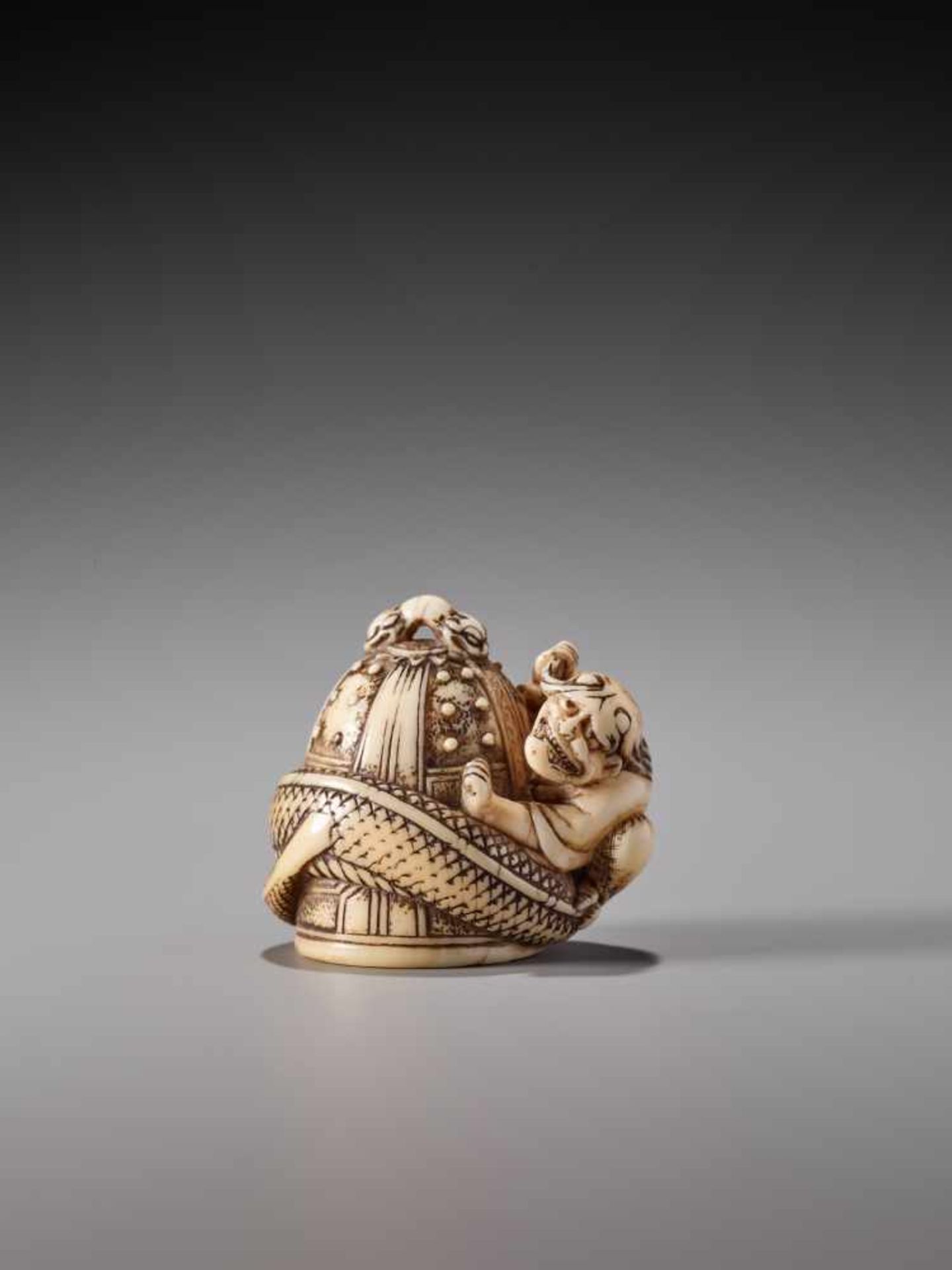 A VERY RARE IVORY NETSUKE OF KIYOHIME WRAPPED AROUND THE TEMPLE BELL IN DOJO-JI BY TOMOKOTOIvory