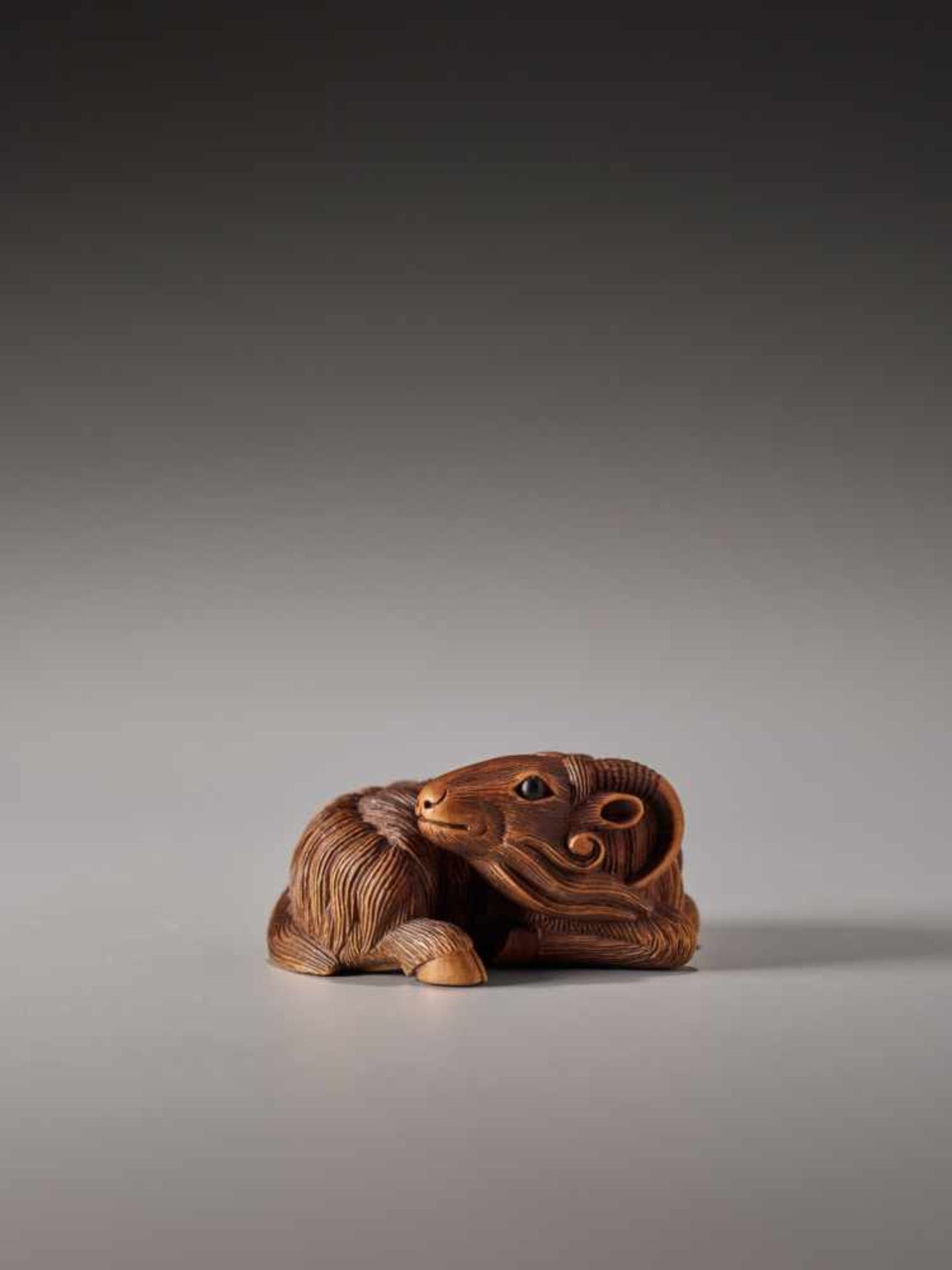 A FINE WOOD NETSUKE OF A RECUMBENT GOATWood netsukeJapan, Kyoto19th century, Edo period (1615-1868)A - Image 3 of 8