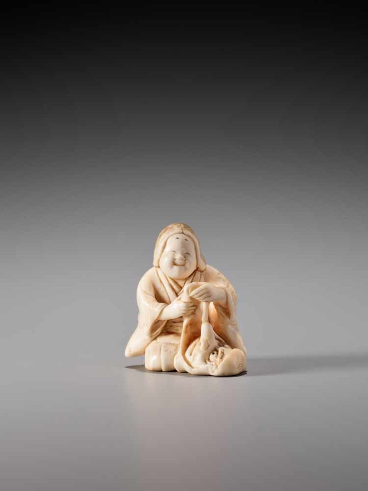 AN IVORY NETSUKE OF OKAME WITH TENGU MASK BY GYOKUZANIvory netsukeJapan, Tokyolate 19th century,