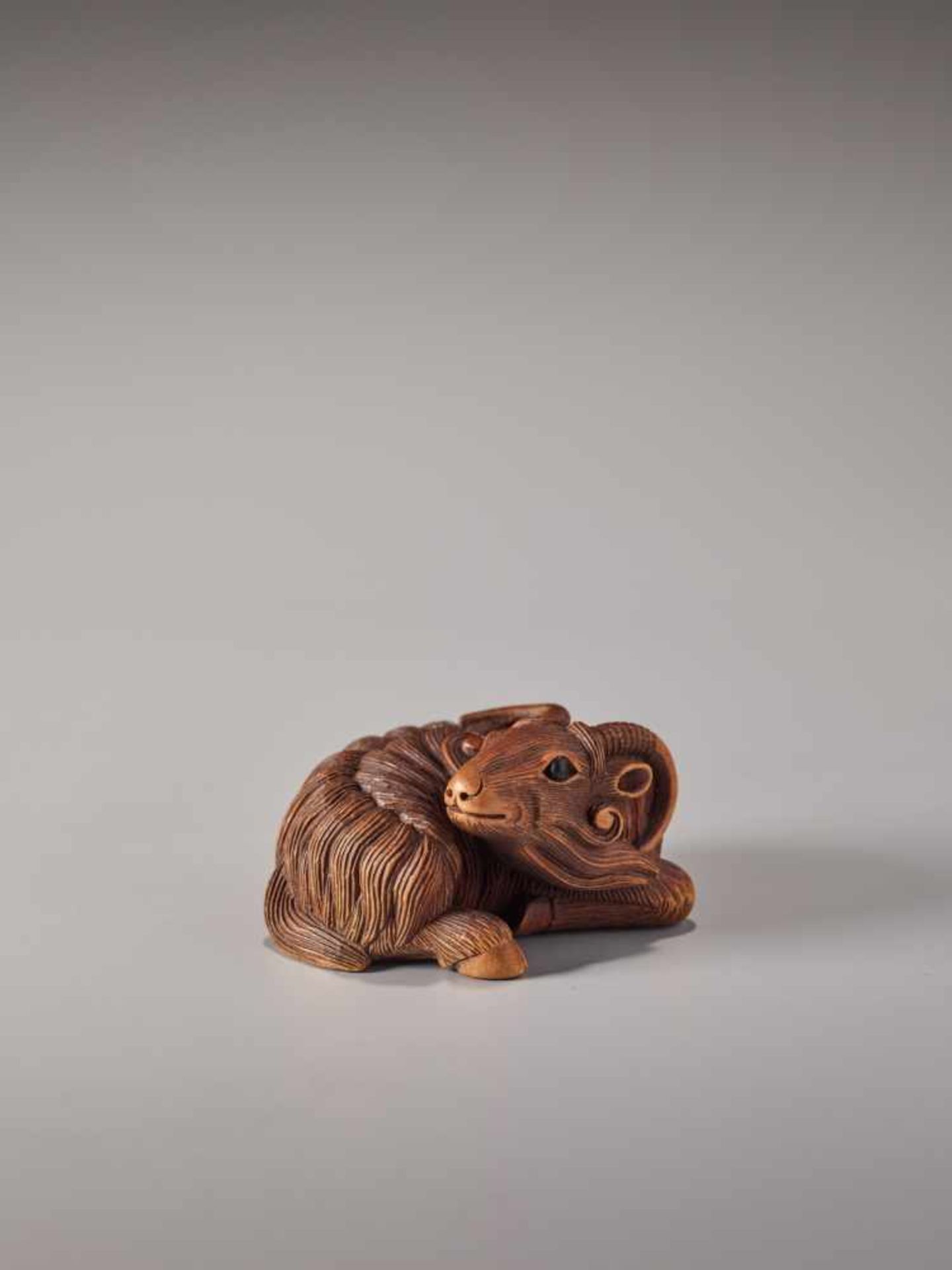 A FINE WOOD NETSUKE OF A RECUMBENT GOATWood netsukeJapan, Kyoto19th century, Edo period (1615-1868)A