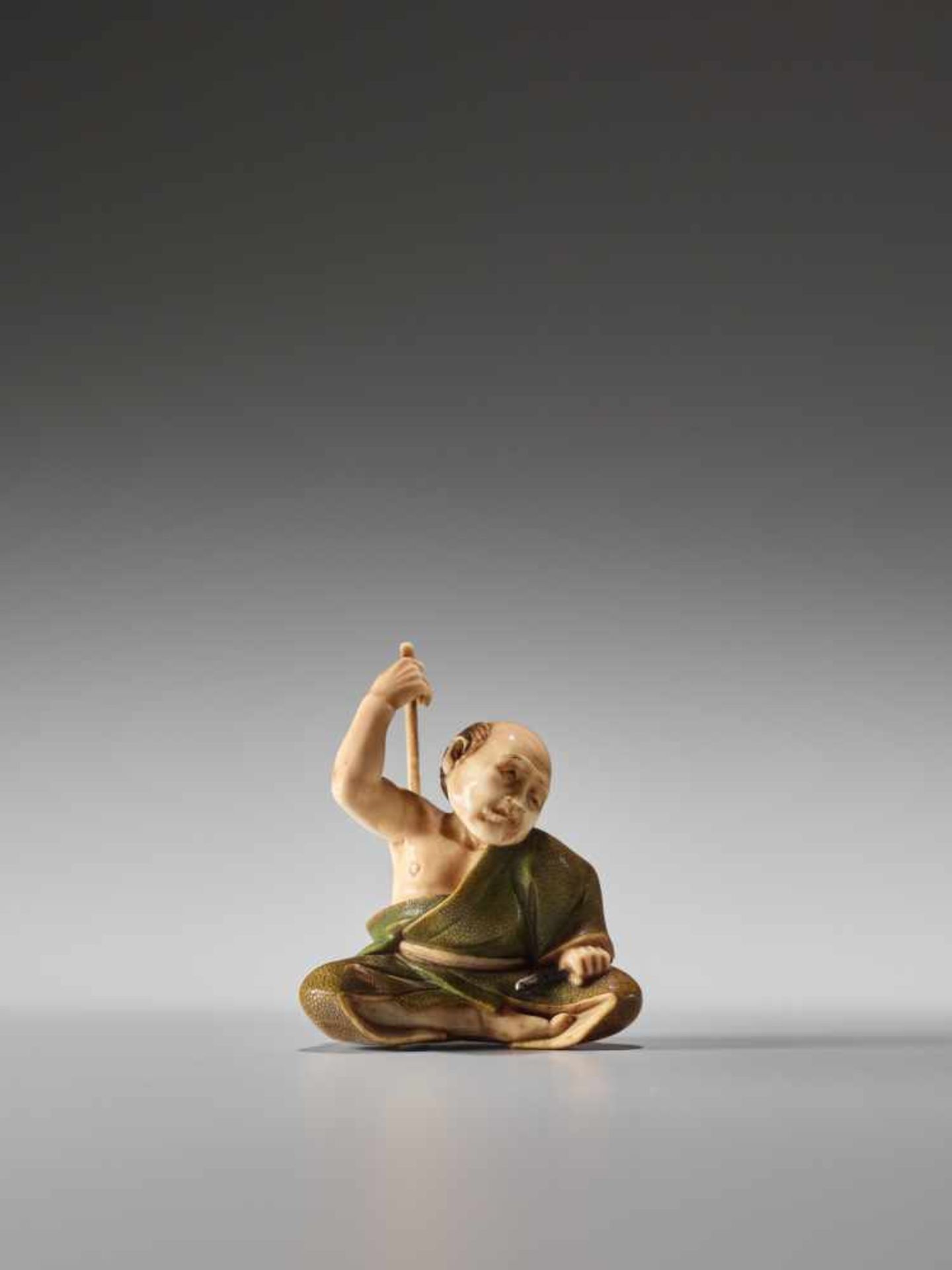 A FINE TOKYO SCHOOL IVORY NETSUKE OF A MAN SCRATCHING HIS BACK BY TOMOYUKIIvory netsuke with