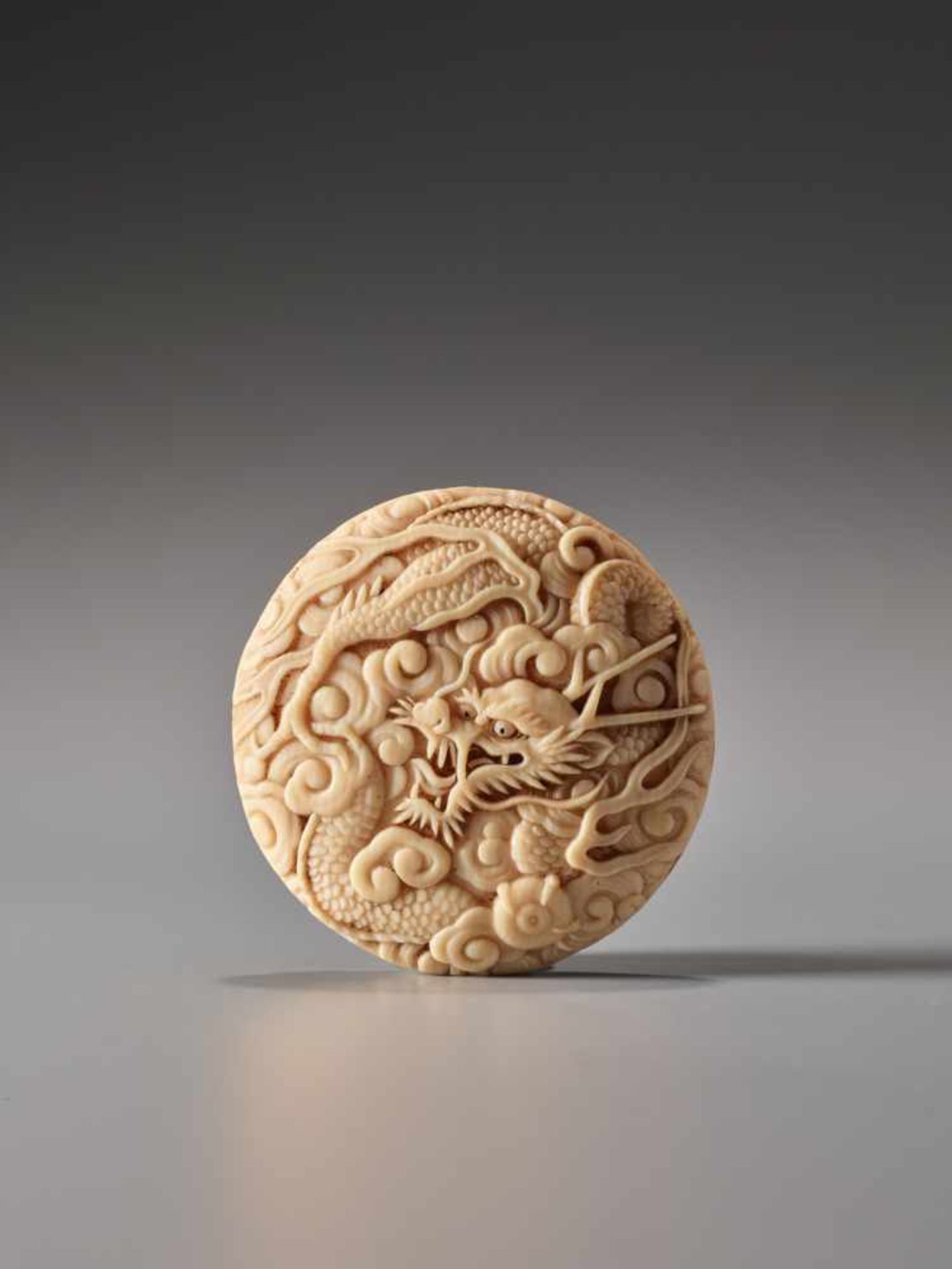 A FINE IVORY MANJU NETSUKE OF A SKY DRAGON ATTRIBUTED TO OKUTAKAIvory manju netsukeJapan19th