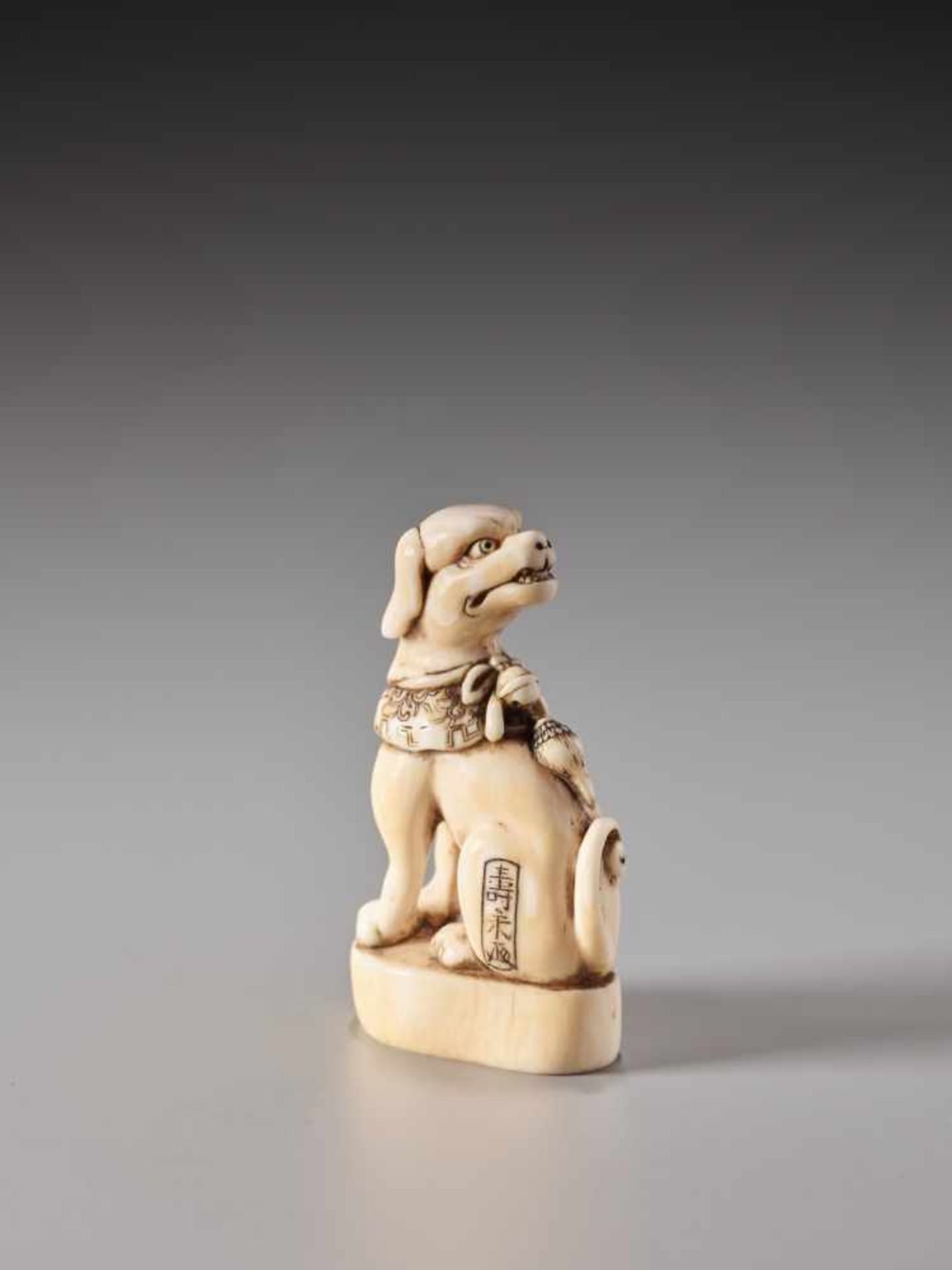 A FINE IVORY SEAL NETSUKE OF A DOG WITH COLLAR AND BELL BY TOSHIHIDE (JUEI)Ivory netsukeJapan19th