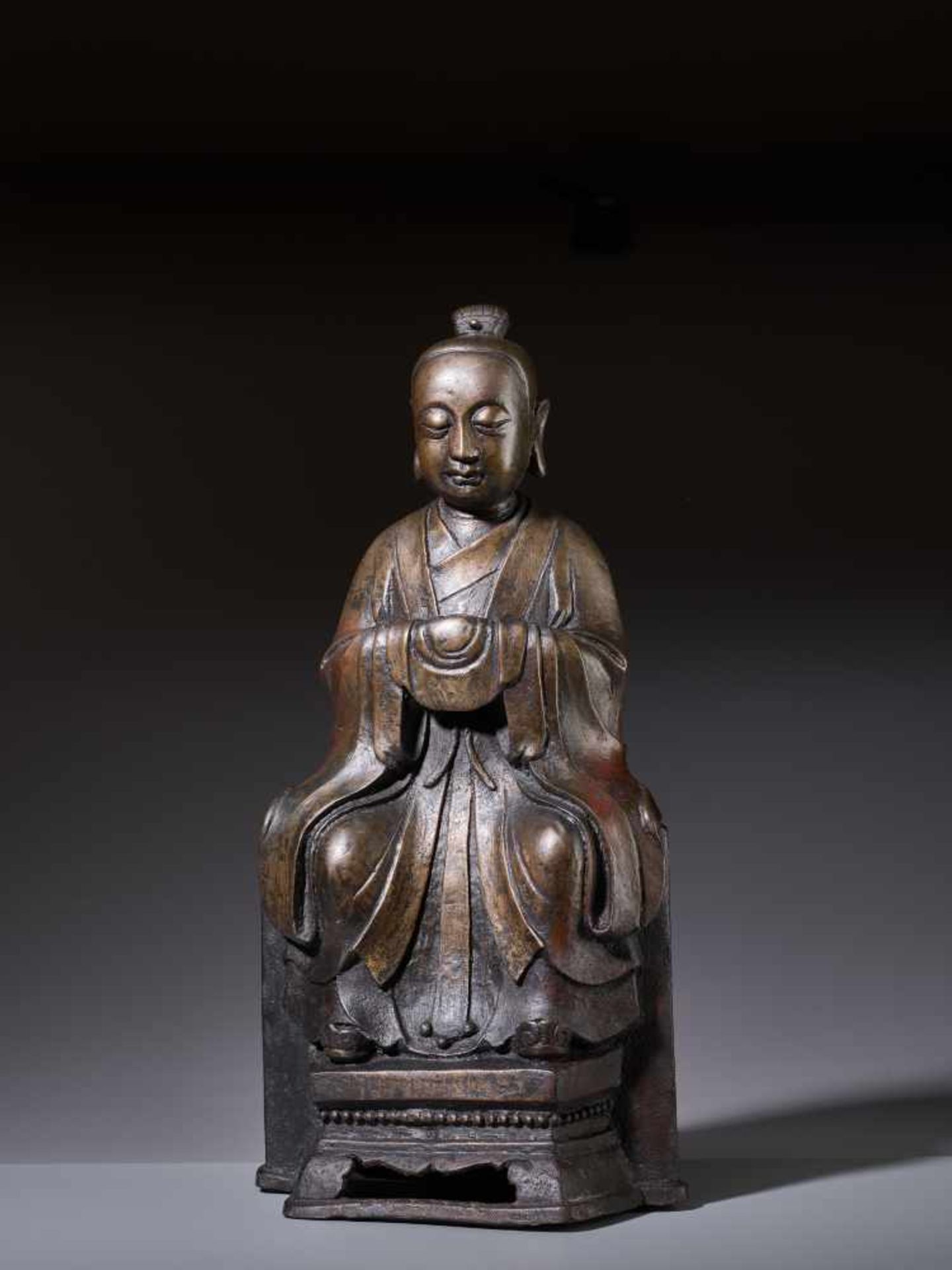 A LARGE BRONZE FIGURE OF A YOUTHFUL DAOIST DEITY, MING DYNASTYCast bronze with incised detail