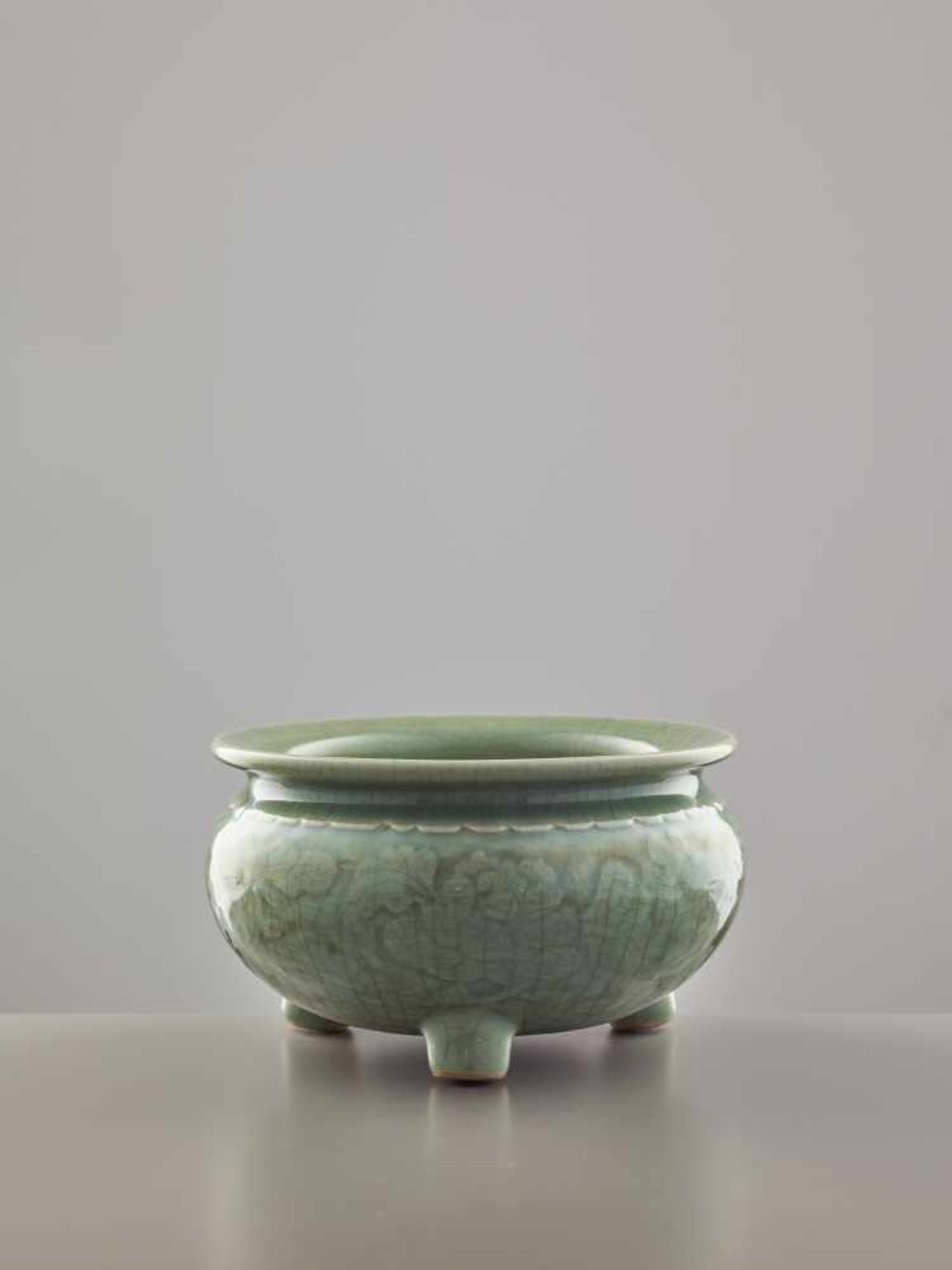 A LONGQUAN CELADON TRIPOD ‘PEONY’ CENSER, MING DYNASTY Celadon glaze stoneware with carved