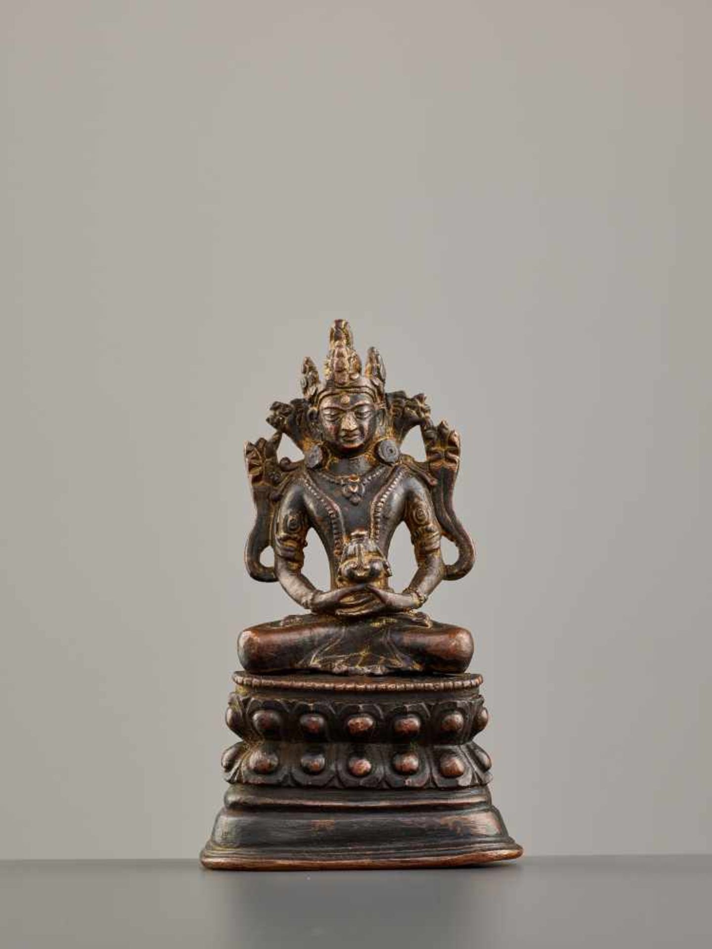A NEPALESE BRONZE FIGURE OF BUDDHA AMITAYUS, 16th – 17th CENTURY Copper bronze alloy, black