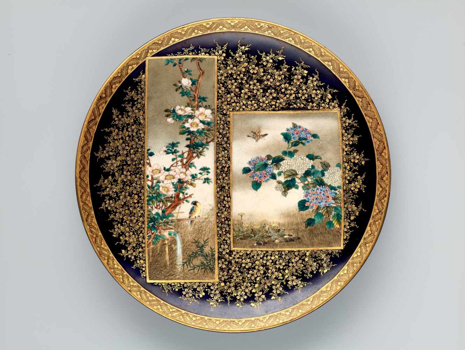 A FINE SATSUMA PLATE BY KINKOZAN WITH BLOSSOMS, BIRDS AND BUTTERFLIESSatsuma ceramicJapan, late 19th