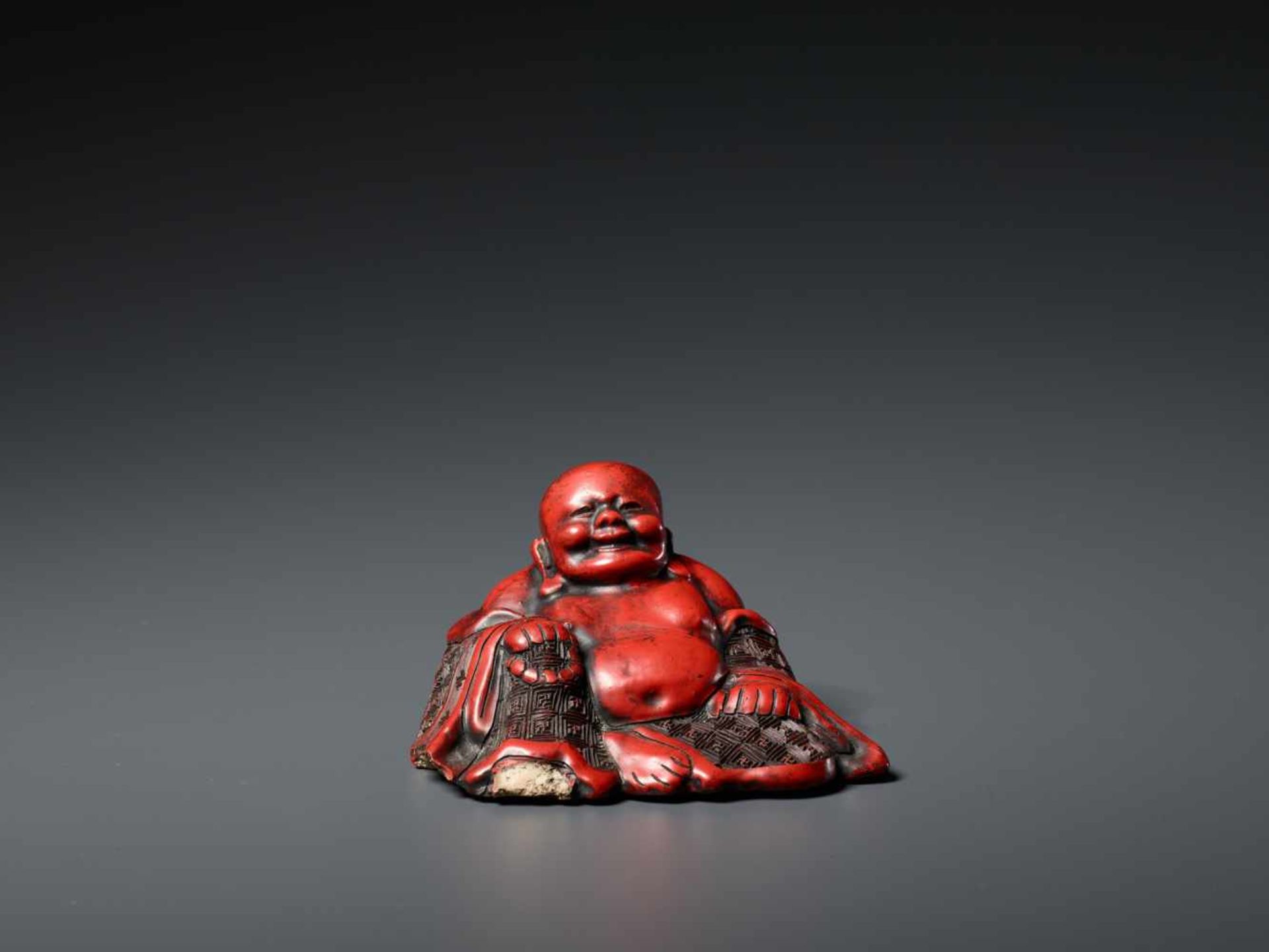 A CINNABAR LACQUER BUDAI, QING DYNASTY, POSSIBLY BY LU GUISHENGThe ceramic statue entirely covered