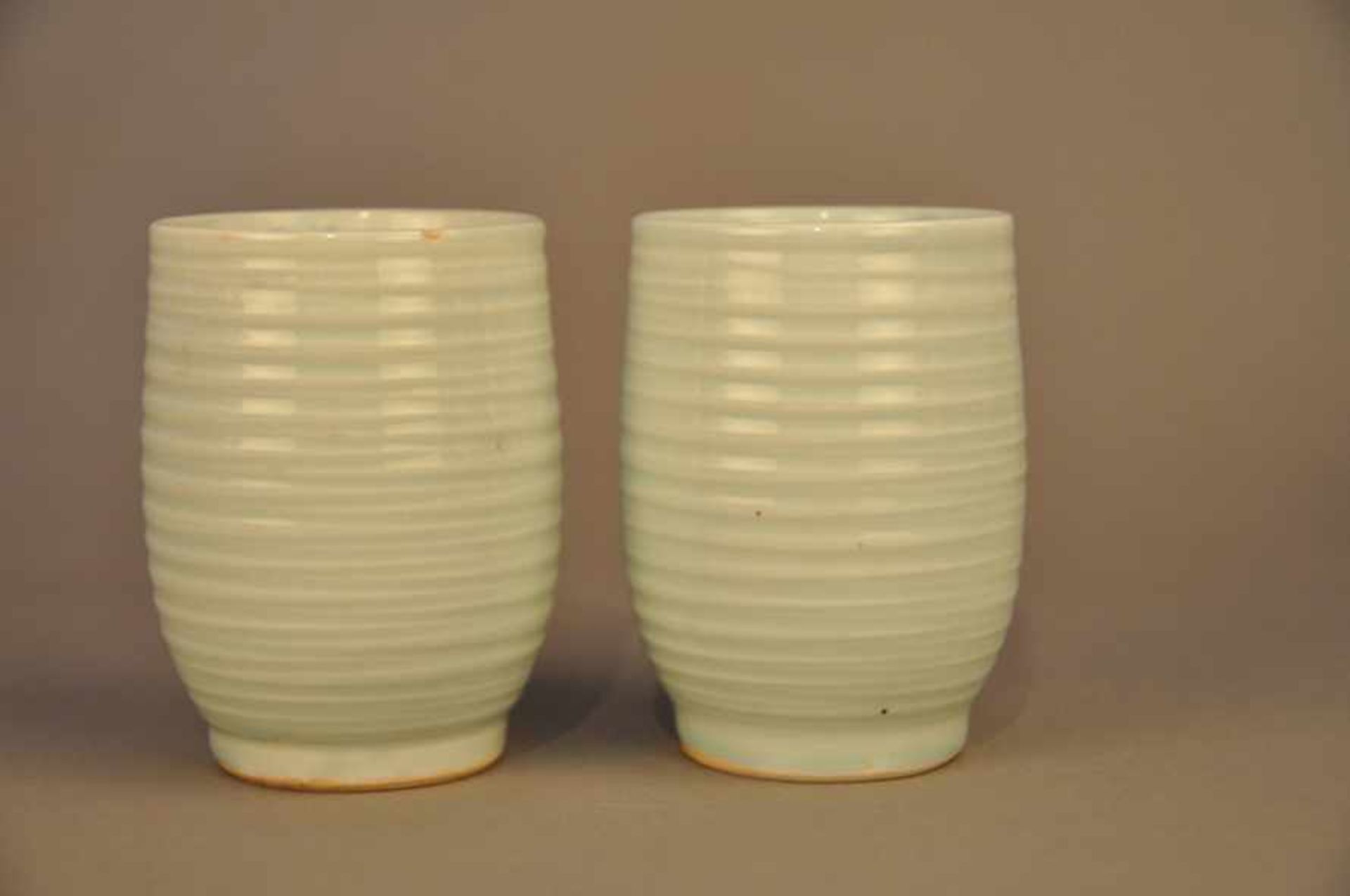 2 asiatische Trinkbecher. Seladonglasur, gemalt, signiert, um 1900. Höhe ca. 9 cm, Stand 4,5 cm.