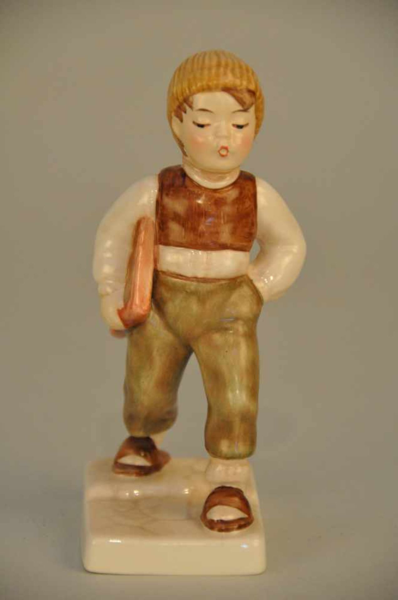 Junger Schulgänger. Porzellanfigur. Goebel 1984. Höhe ca. 14 cm, Stand 8 x 5,5 cm.