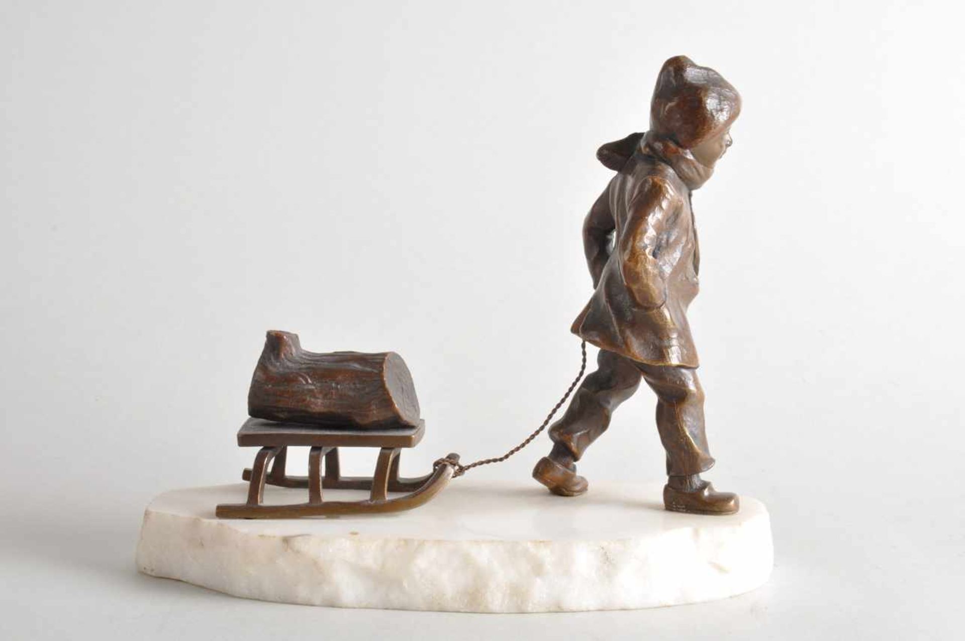 Die winterliche Holzlieferung, Knabe mit Schlitten.Bronze auf Steinsockel. Datierung um 1920, - Bild 2 aus 4