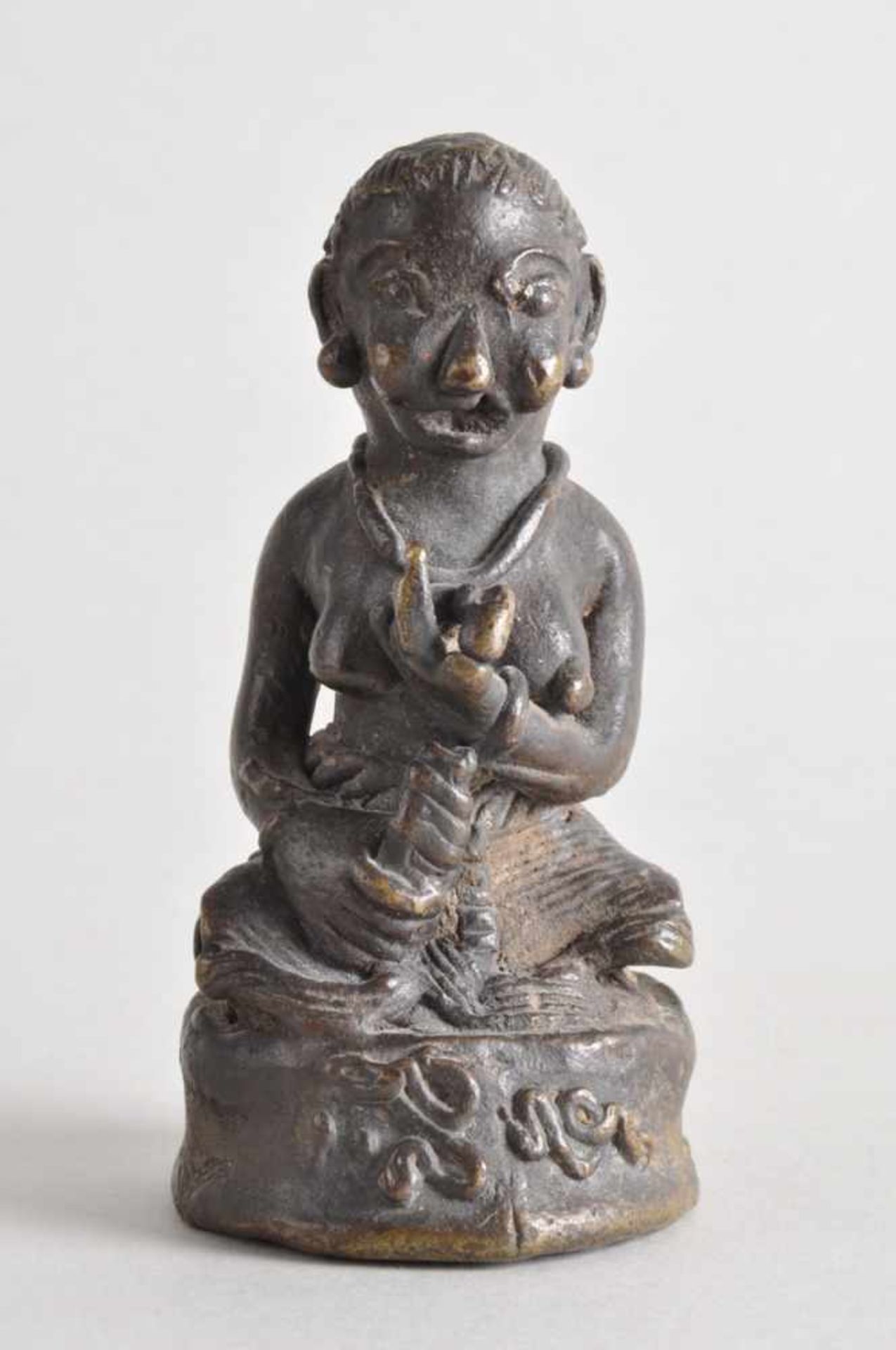 Asiatische Heiligenfigur mit Attributen (u.a. Bilvafrucht).Bronze massiv, wohl 17./18.
