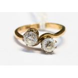 A 9ct gold crossover ring claw set with two white stones, size L½,