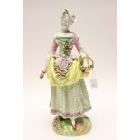 A large Meissen style figure of a woman with basket and garlands, florally encrusted,