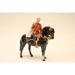 A Beswick figure of a Canadian Mountie on horse back, with blue seat marked NP,