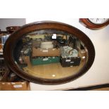 An early 20th Century oak framed oval wall mirror,