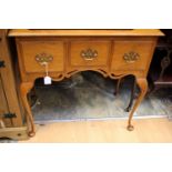 A George I style oak lowboy, fitted with three drawers, raised on cabriole legs,