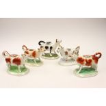 Five various Staffordshire early 19th Century cow creamers to include Sponge ware,