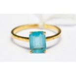 An 18ct gold ring, claw set with a rectangular cut blue stone, ring size V,