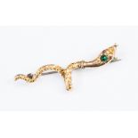 A Victorian serpent brooch in gilt metal, with a green stone set to the head and red eyes,