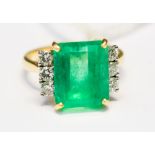 An emerald and diamond 18ct yellow gold ring the centre claw set emerald cut emerald measuring