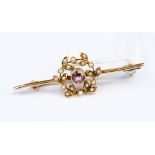 A 9ct seed pearl and pink stone bar brooch, set centrally with a round stone,