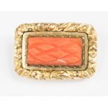 A carved coral brooch,