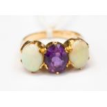 An opal and amethyst ring, set with two oval opals either side of an oval amethyst,