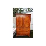 A George III linen press, with two door with oval panels of flame mahogany veneer,