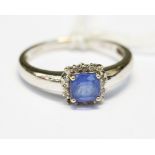 A white gold ring set with tanzanite ring, cushion cut, with a halo surround of diamond, size N,