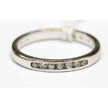 A diamond and platinum ring, channel set with seven diamonds, size O 1/,