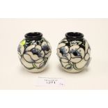 A pair of Moorcroft Trial miniature vases, both 1st quality, white flowers on black ground,