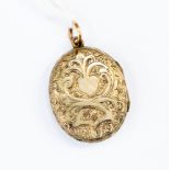 Yellow metal oval locket circa 1840, with engraved foliate detail, approx size 15mm x 20mm,