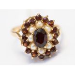 A garnet and seed pearl cluster ring, set in 9ct yellow gold,