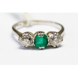 An emerald and diamond ring, set with a central emerald,