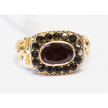 A Victorian mourning ring, set with a foil backed pink/red stone possibly garnet,