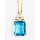 A Blue topaz and 9ct gold pendant, comprising a large claw set step cut rectangular blue topaz,