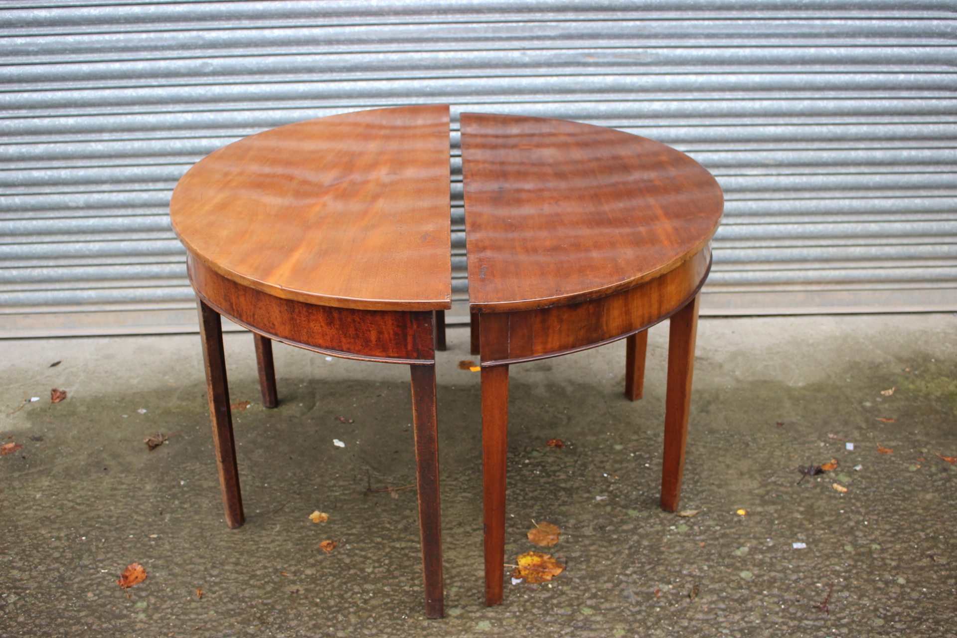 A pair of George III mahogany demi-lune tables, circa 1790, each measuring 73cm high, 122cm wide,