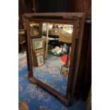 A contemporary bevelled edge mirror, having an elaborately moulded frame,