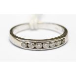 An 18ct white gold diamond half eternity ring, channel set with seven diamonds size J,