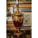 A large baluster shape lamp base, maroon ground with applied gilt fittings,