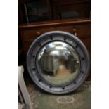 A large convex mirror with silver painted frame,