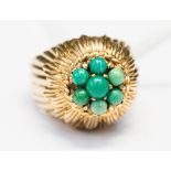 A 1950s 9ct gold and turquoise dress ring with a gold flower layer detail set to the top with seven