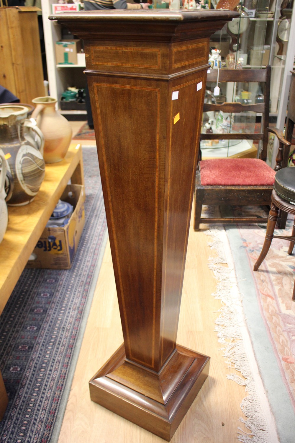 An Edwardian mahogany and satinwood cross-banded torchere of square sectioned tapering form,