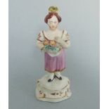 A small colourful English porcelain figure of a young girl holding flowers in her apron Circa
