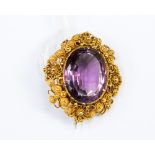 A 19th Century cannetille work single stone amethyst yellow metal brooch,