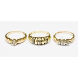 Three diamond set 9ct gold rings to include a three stone ring with twist shoulders, size N,