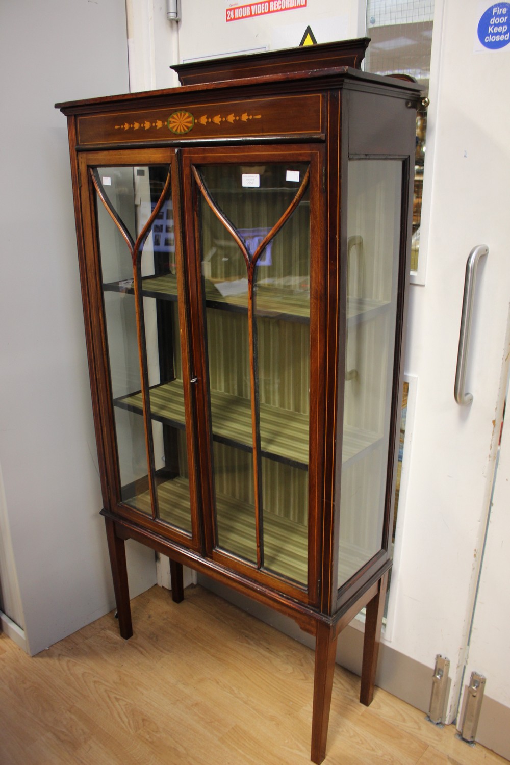 An Edwardian mahogany two door display cabinet, enclosing two shelves, strung in boxwood,