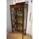 An Edwardian mahogany two door display cabinet, enclosing two shelves, strung in boxwood,